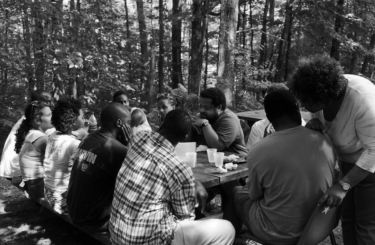 From one of the BLT lunch tables. Image features a group of people talking amongst each other. There are remnants of lunch on the table.