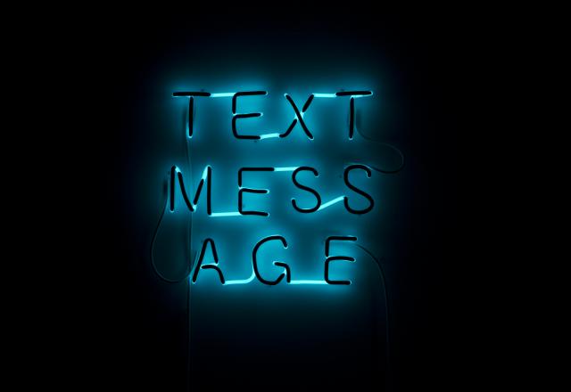 Detail of the neon sign. It reads "TEXT MESSAGE". 