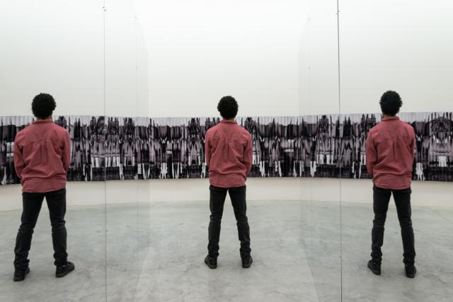 Man standing between mirrors being reflected 3 times