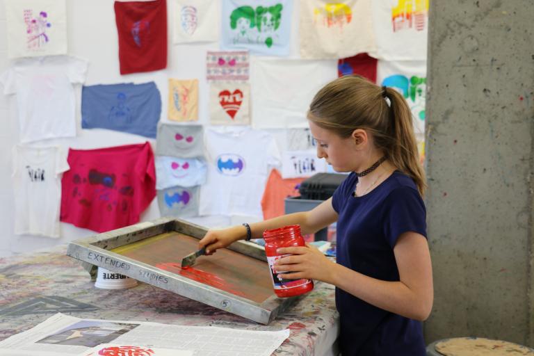 young person painting on a silk screen